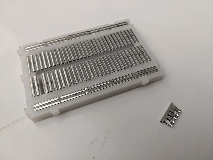 Breadboard with the back removed, showing metal strips